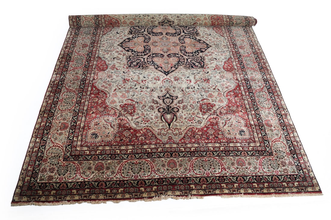 HAND-KNOTTED WOOL INDIAN PALACE SIZED RUG: Labeled Made In India underneath. Hand-knotted wool rug with floral and geometric design. Dimensions: L 213" x W 144". Condition: Wear consistent with age and use. Minor sun fading and frays to ends.