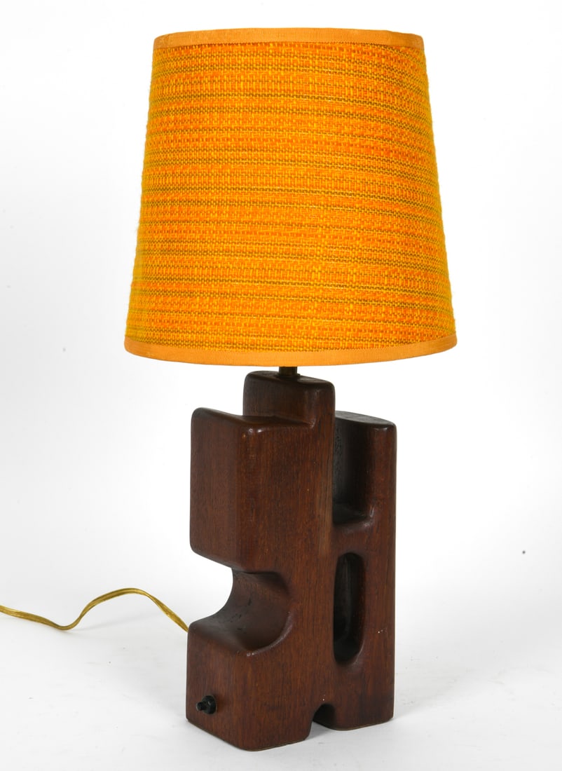 MID-CENTURY DANISH SCULPTURAL TEAK TABLE LAMP: Wooden table lamp featuring a cut-out geometric design and orange textured lampshade. Dimension: H19.25 " x Dia. 9.5" Condition: Not tested, Cord cut, Wear consistent with age and use. Spots of soilin