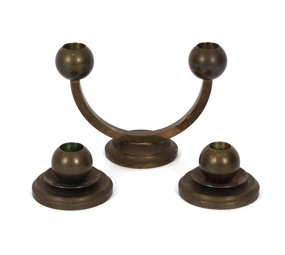 3 KOLBACK STYLE SWEDISH BRASS CANDLEHOLDERS 1950S: Deco style brass candlesticks. Sweden, circa 1950s. Dimensions: H 4.5" x W 3" x D 6.75" Condition: Oxidation and patina present. Wear consistent with age and use, including rubs and scuffs.