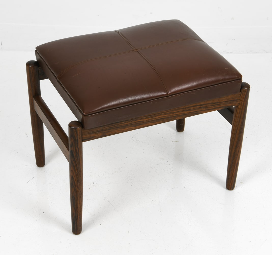 STYLE HUGO FRANDSEN DANISH ROSEWOOD OTTOMAN: Leather upholstered seat and rosewood frame. Denmark, circa 1970s. Dimensions: H 16.5" x W 20" x D 14.5" Condition: Wear consistent with age and use including minor rubs and scuffs to legs and seat.