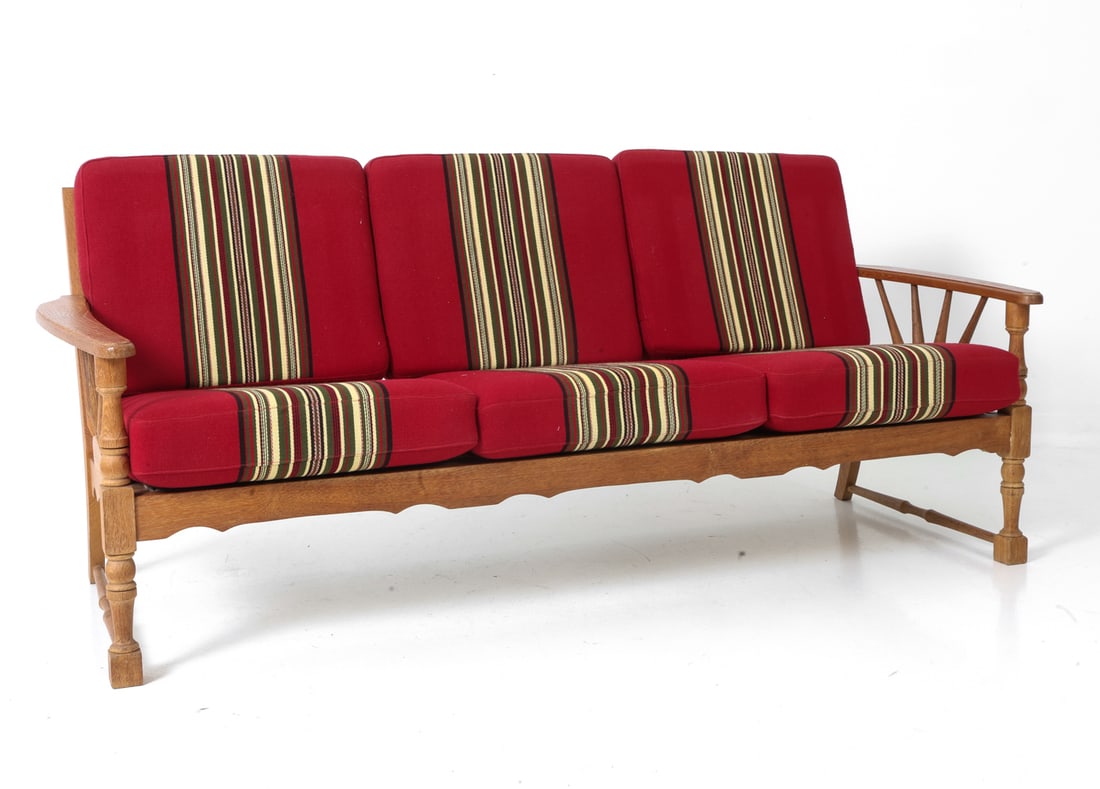 ATTR. HENNING KJAERNULF DANISH OAK SOFA C. 1970S: Three-seater sofa in oak with carved details and red stripe upholstery. Denmark, circa 1970s. Dimensions: H 31" x W 65" x D 32" x SH 16" Condition: Wear consistent with age and use. Some scuffs, minor