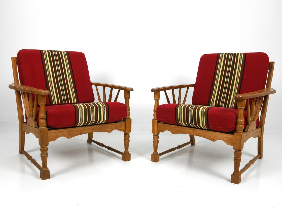 PAIR ATTR. HENNING KJAERNULF OAK LOUNGE CHAIRS: Two armchairs in oak frame with carved details and red stripe upholstery. Denmark, circa 1970s. Dimensions: H 30.5" x W 29" x D 30" x Sh 16.25" Condition: Wear consistent with age and use, including m
