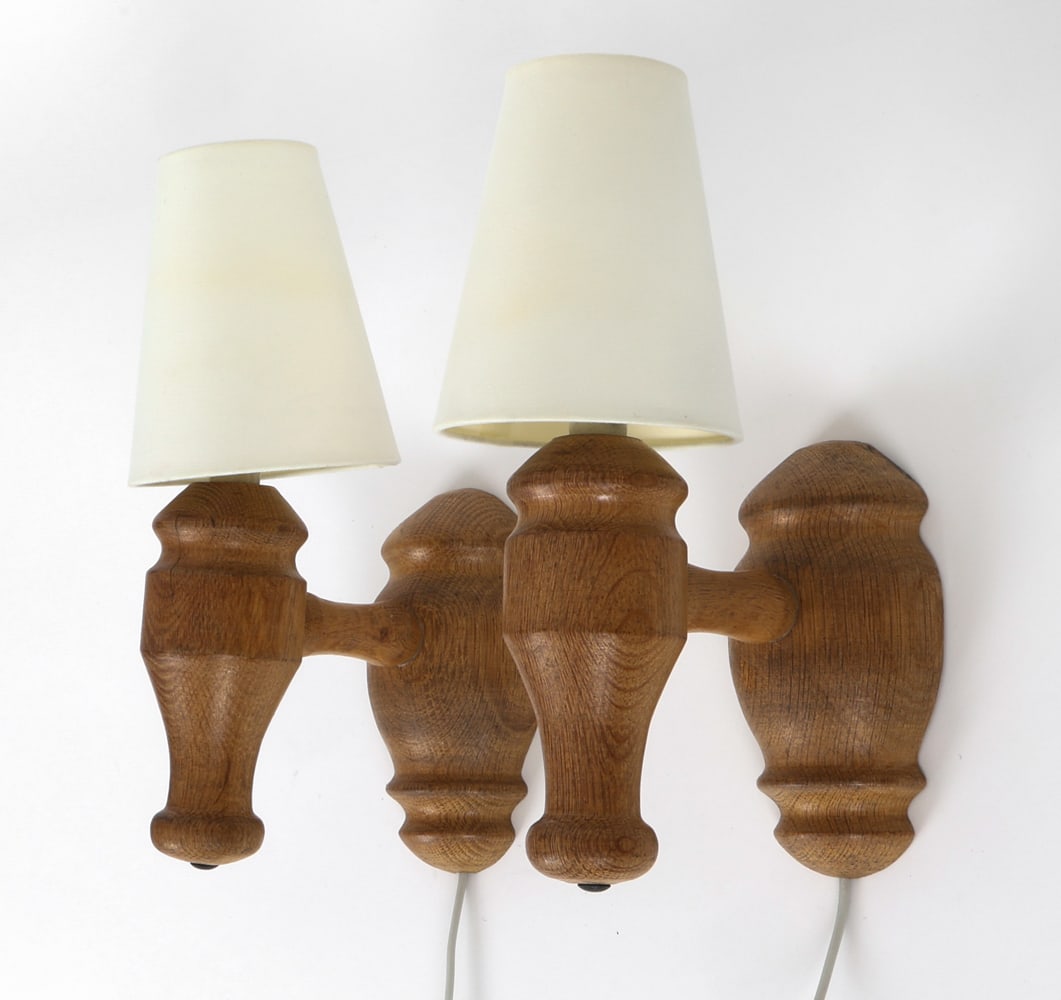 PAIR OF SCANDINAVIAN OAK WALL SCONCES 1960'S: Hand carved oak sconces. Shades included. Circa 1960's. Dimensions: H 12" x W 5" x D 8" Condition: Not tested, the cord cut, Wear consistent with age and use. One sconce is loose.