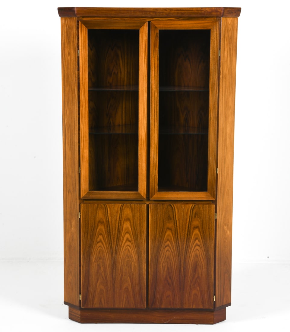 SKOVBY DANISH ROSEWOOD CORNER CABINET C. 1970S: Rosewood corner cabinet with glass shelves and glass panels to cabinet doors. Marked to back. Denmark, circa 1970s. Dimensions: H 66.25" x W 37.25" x D 20.75". Condition: Faint scuffs and rubs, Wear c