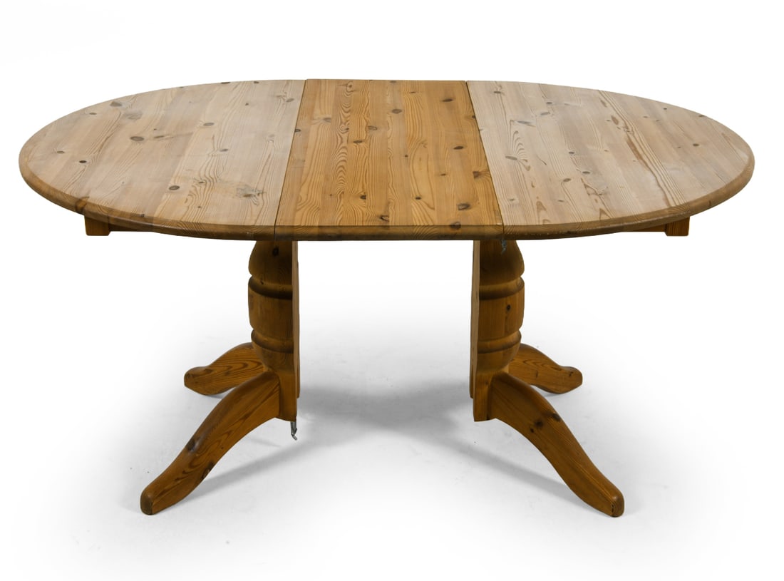 SWEDISH PINE EXPANDING DINING TABLE C. 1970S: (1) Leaf included. Dimensions: H 28.5" x Dia. 43.5". Leaf W 15.5". Condition: Scuffs and scratches, few discolored patches to top. Wear consistent with age and use.