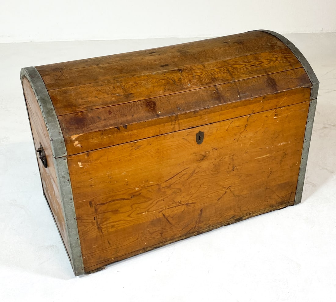 ANTIQUE SWEDISH PINE DOME TOP TRUNK: Dome-top chest with metal accents to edges and iron handles. Sweden. Dimensions: H 25" x W 36.5" x D 21". Condition: No key. Scuffs, scratches, and dings to wood. Minor oxidation to metal in places. W