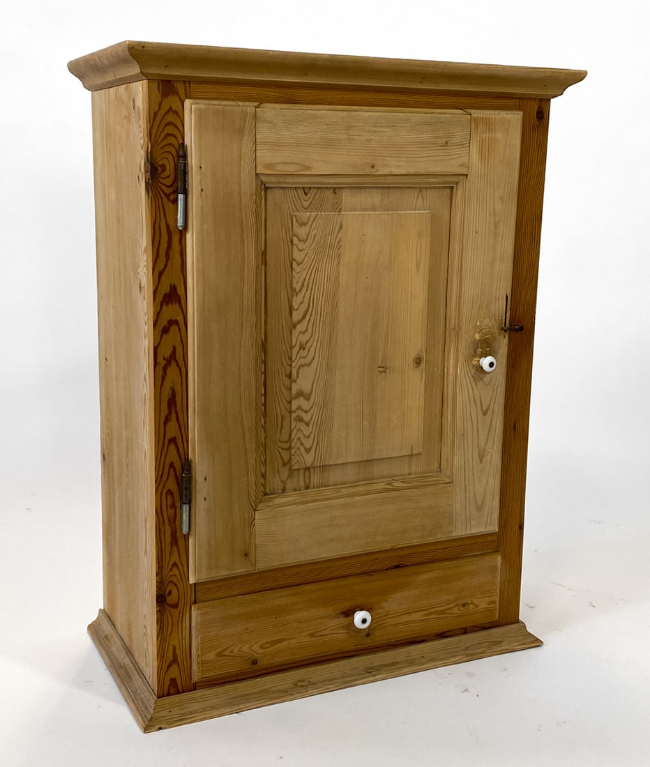 SWEDISH PINE HANGING WALL CABINET C. 1970S: Ping hanging wall cabinet with (1) drawer. Removable shelf. Ceramic pull to drawer. Sweden, circa 1970s. Dimensions: H 34" x W 25.5" x D 13.25". Condition: Water rings inside. Minor scuffs and scratch