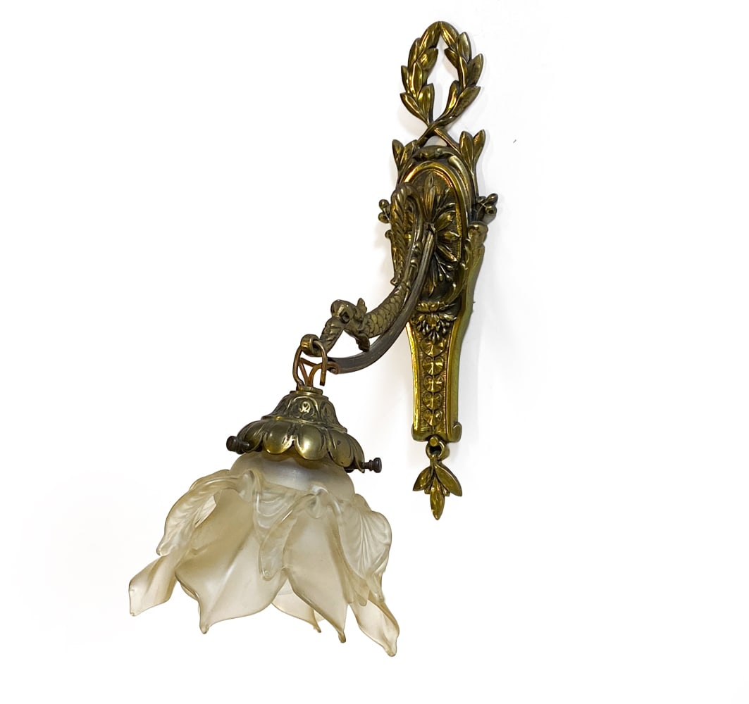 ART NOUVEAU STYLE BRASS & GLASS WALL SCONCE: Brass mount with frosted glass floral shade. European, 20th century. Dimensions: H 13" x W 6" x D 8". Condition: With patina to brass elements and small chips to glass shade. Wiring not tested