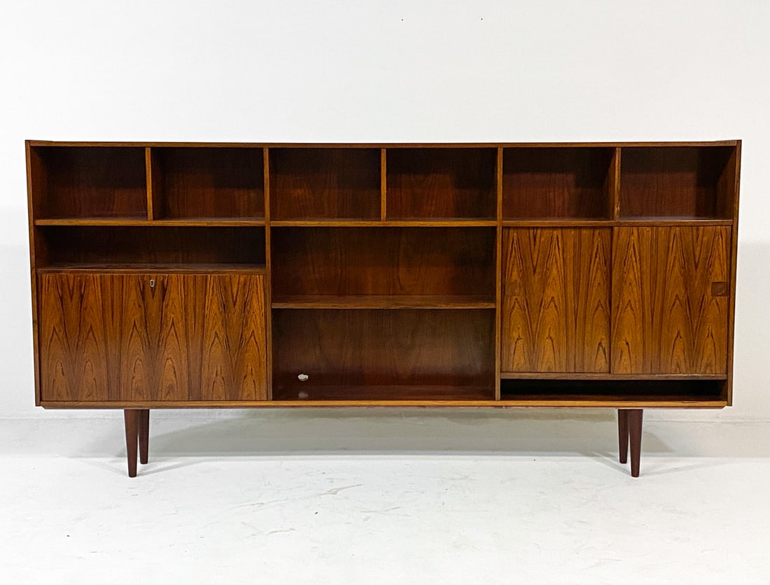 OMANN JUN STYLE DANISH ROSEWOOD SIDEBOARD C. 1960S: Key included. Adjustable shelves. Drop-down cabinet with lock. Frosted glass to back of left cabinet. Denmark, circa 1960s. Dimensions: H 47" x W 95" x D 10. Condition: Slight sun fading. Small cut-ou