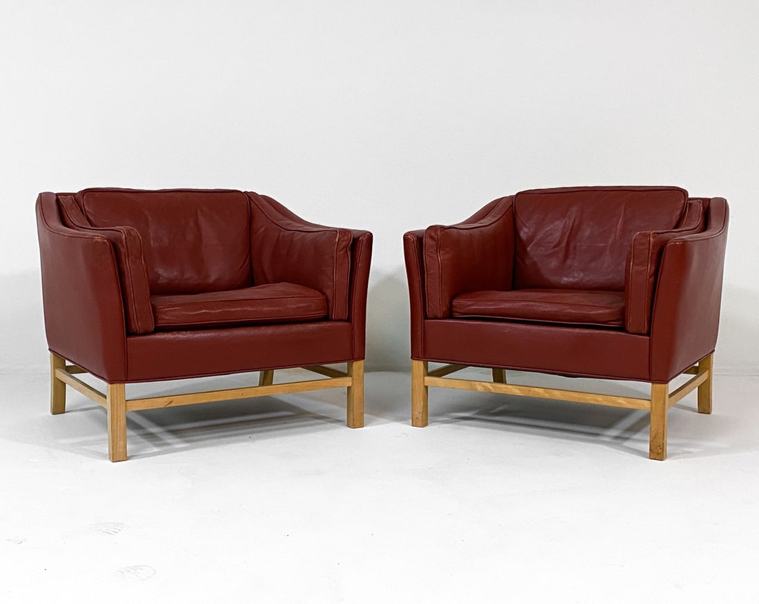 ATTR. GEORG THAMS DANISH LEATHER LOUNGE CHAIRS: Red leather upholstery with beech legs. Denmark, circa 1960s. Dimensions: H 28" x W 33" x D 30" x SH 17.25". Condition: Scuffs and rubs to leather cushions, few faint scuffs to legs. Wear consistent w