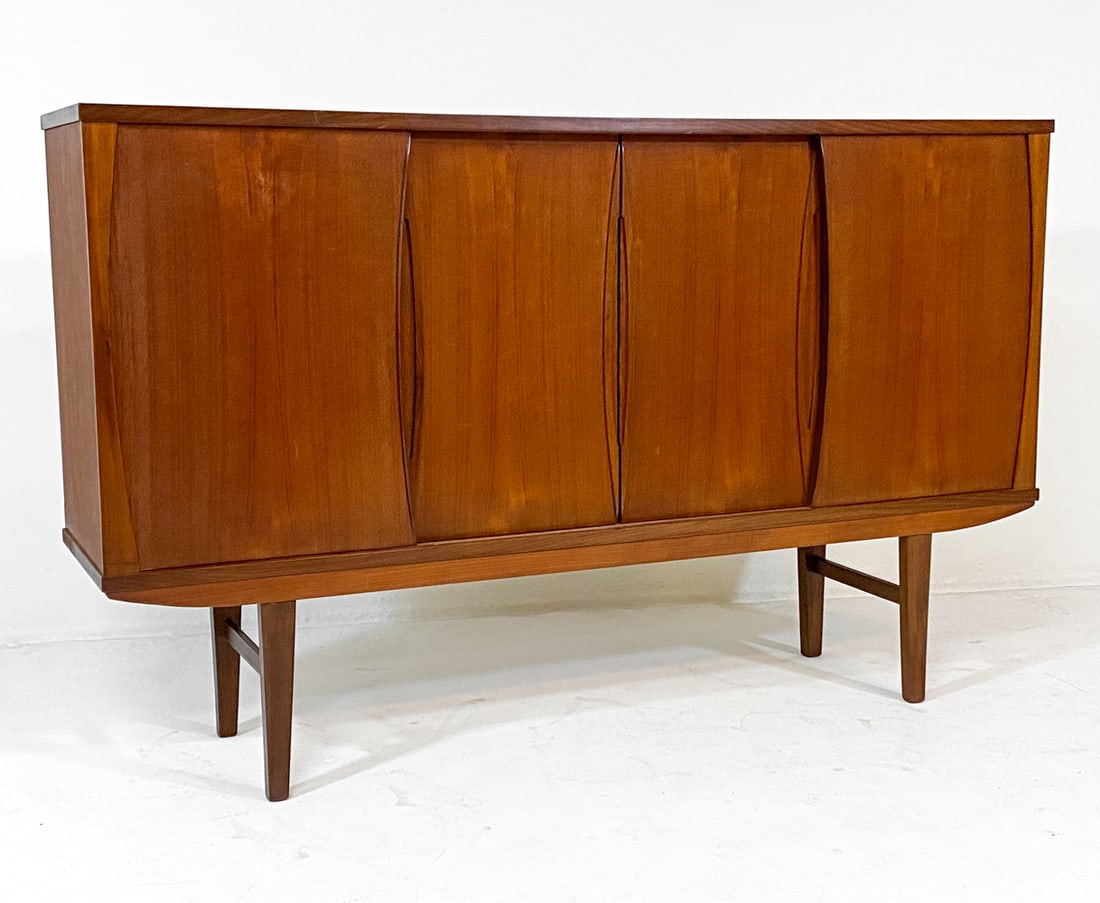 E.W. BACH STYLE DANISH TEAK SIDEBOARD C. 1960S: Adjustable shelves. Mirror backing to center cabinet with frosted decoration. Felt lined drawers. Denmark, circa 1960s. Dimensions: H 45.5" x W 73" x D 17". Condition: Faint scratches, small dings. Mi