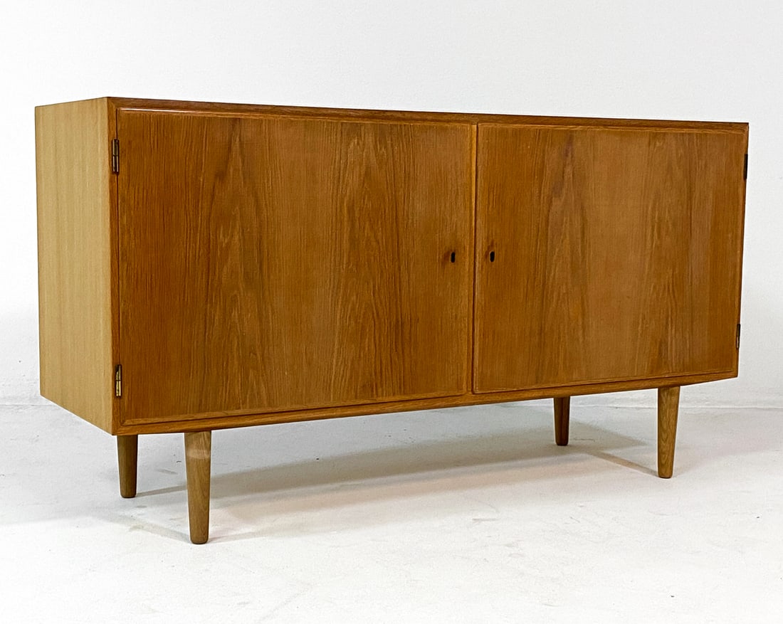 POUL HUNDEVAD DANISH TEAK CABINET C. 1970S: Key included. Stamped to back top corner. Adjustable shelves. Denmark, circa 1970s. Dimensions: H 30" x W 54.5" x D 17". Condition: Sun fading to top. Small ding to back top edge. Wear consistent with