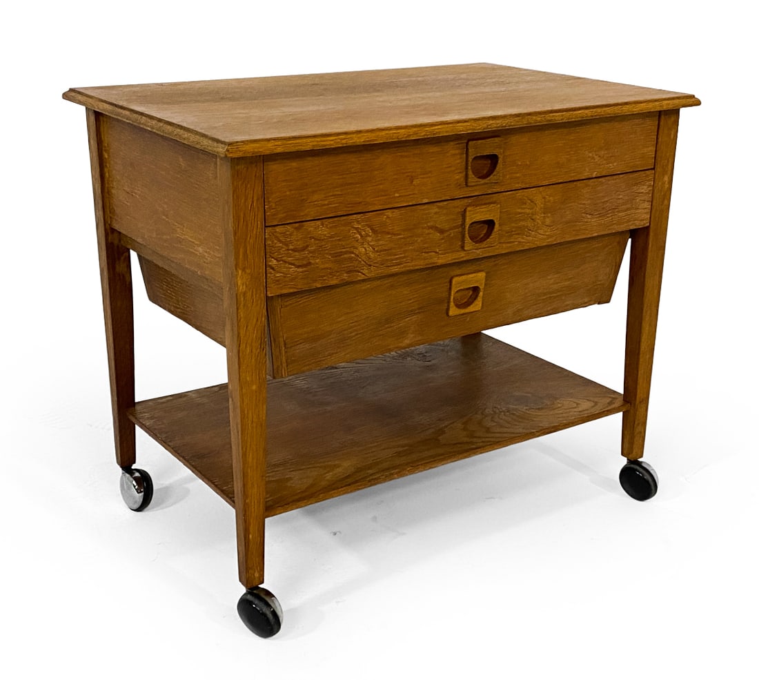 DANISH OAK SEWING CHEST C. 1960S: Oak side chest with castors. Molded inset drawer pulls. Denmark, circa 1960s. Dimensions: H 20" x W 24" x D 16". Condition: Water spots to top, wear consistent with age and use. V088