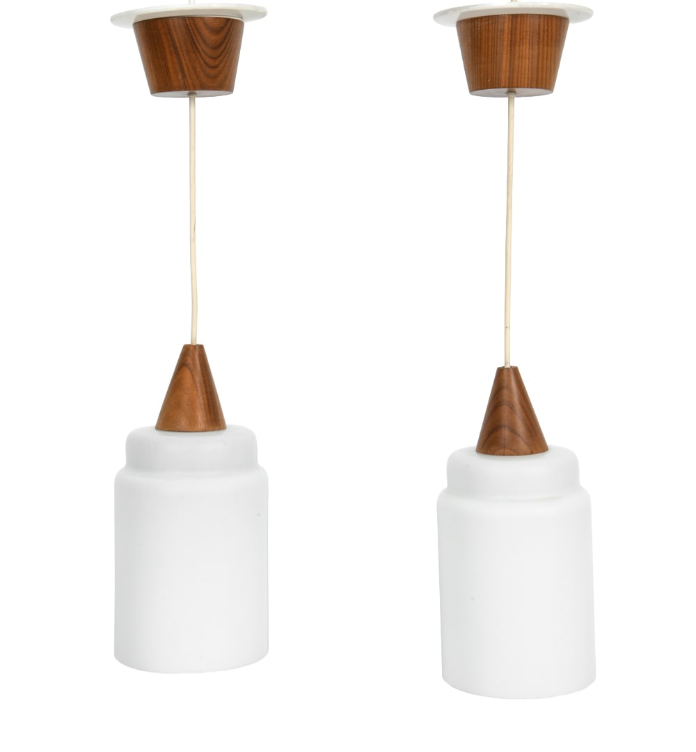 (2) SCANDINAVIAN TEAK & GLASS PENDANT LAMPS 1960S: (2) Pendant lamps, with milk glass shades and teak fixture. Scandinavian, circa 1960's. Dimension: H 11" x Dia. 5.25" Condition: Faint fleabite chips to glass shade rim, minor stress cracks to one lam