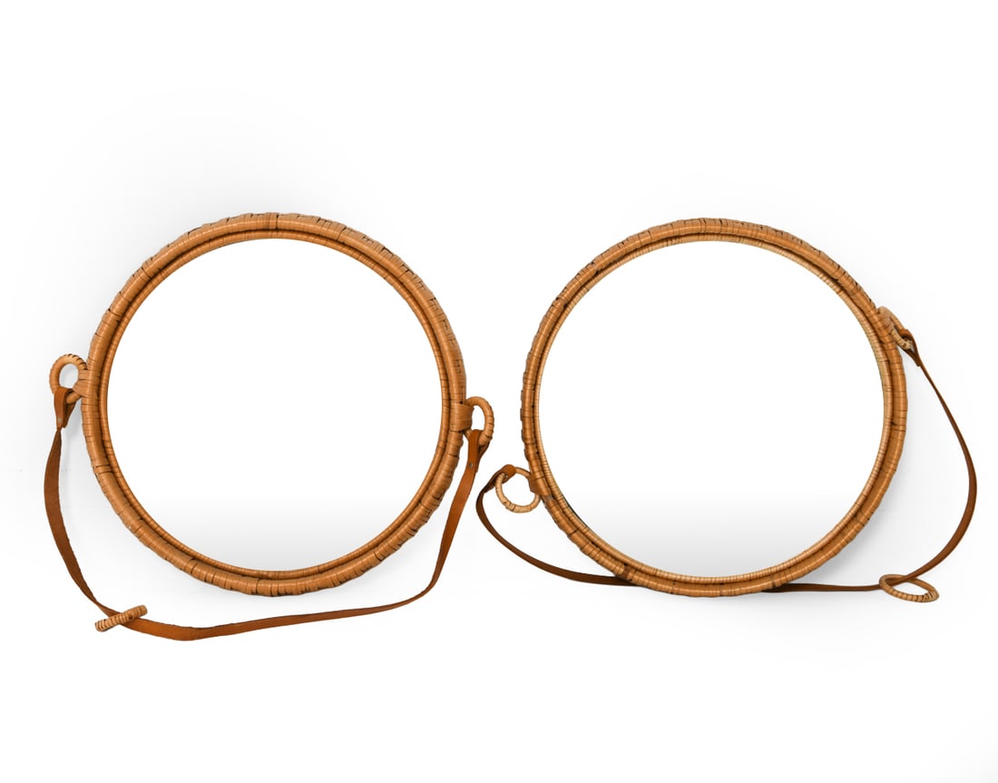 PAIR OF IKEA 'SUSANNE' RATTAN & LEATHER MIRRORS: Pair of rattan wrapped mirrors featuring leather straps to hang. Sweden, circa 1960s. Dimensions: Dia 16.75" Condition: Breaks, small losses and surface marks to rattan. Straps with some rubs, wear co