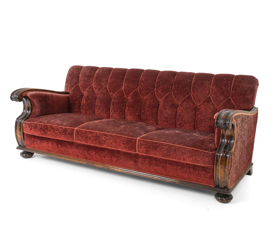 SWEDISH VELOUR SOFA C. 1940S: With faded red velour upholstery, carved birch armrests & legs. Sweden, circa 1940s. Dimensions: H 30.25" x W 76" x D 32" x Sh 15" Condition: Rubs and scuffs to armrest and legs, Wear consistent with