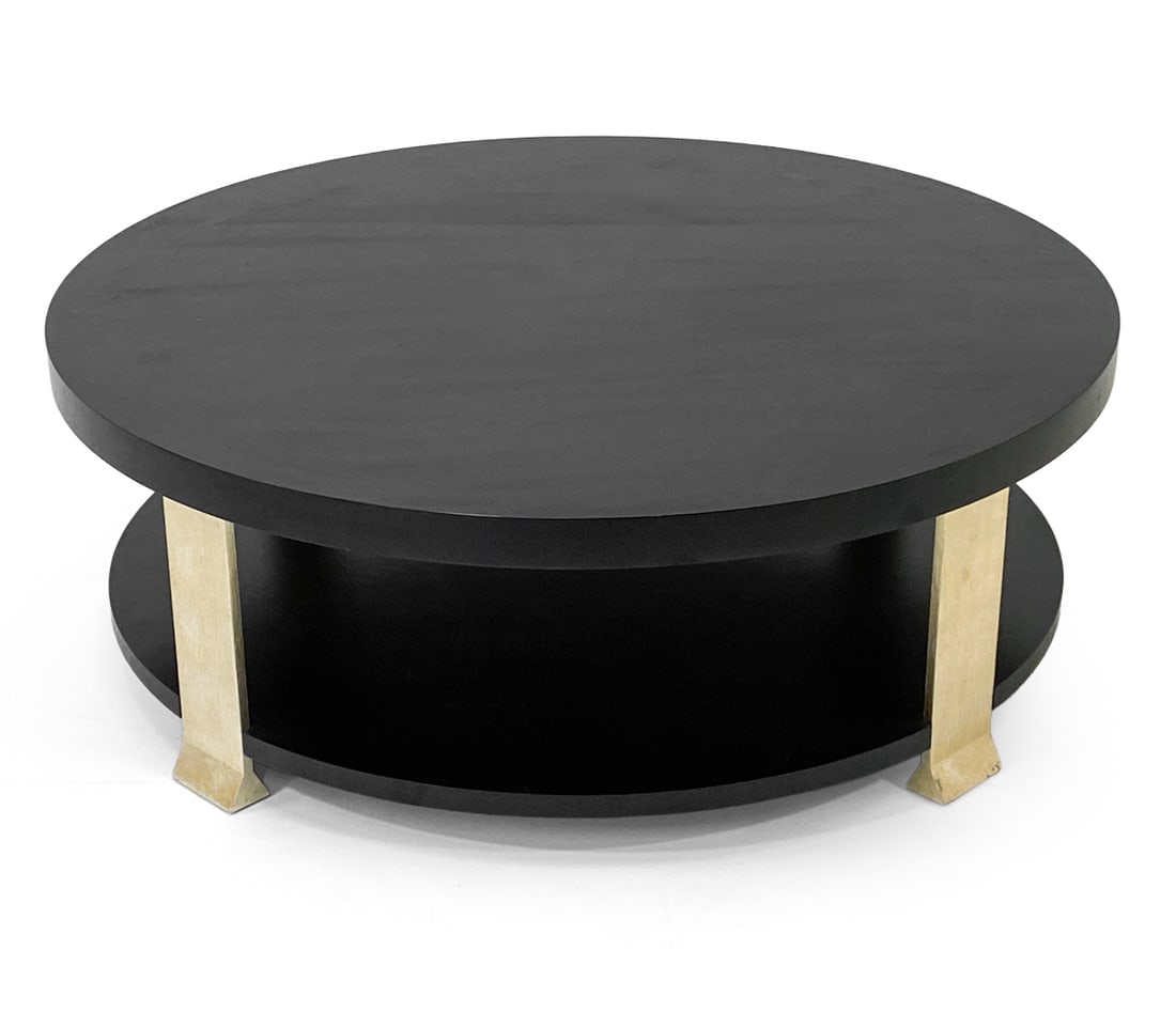 CONTEMPORARY EBONIZED COFFEE TABLE: Ebonized round coffee table with metal feet. Dimensions: H 15" x Dia. 43.5". Condition: Thin surface scratches to top. Wear consistent with age and use.