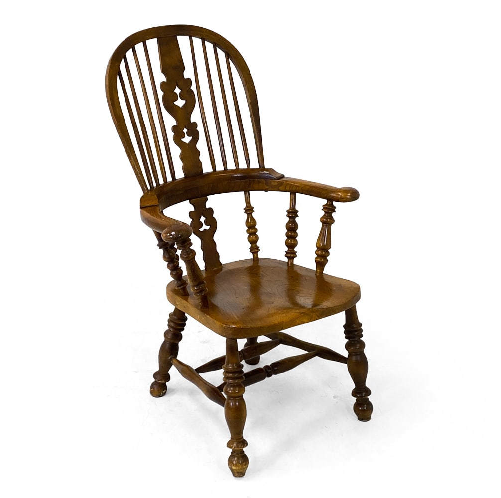 ANTIQUE ENGLISH ELM WINDSOR ARMCHAIR: English Windsor armchair with decoratively carved frame. High hoop splat back and turned legs united by a stretcher. England, circa 19th century. Dimensions: H 43" x W 27.5" x D 22.5" x SH 25.75". Con