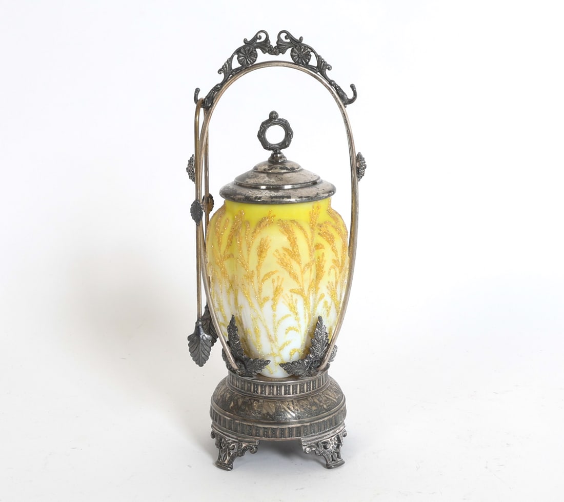 VICTORIAN YELLOW CAMEO GLASS PICKLE CASTOR: Marked for Aurora Silver Plate underneath. Cameo glass with glitter decoration. Tongs included. American, circa 1880s. Dimensions: Castor H 11" x W 4.5" x D 3.5". Tongs L 7". Condition: Showing signs