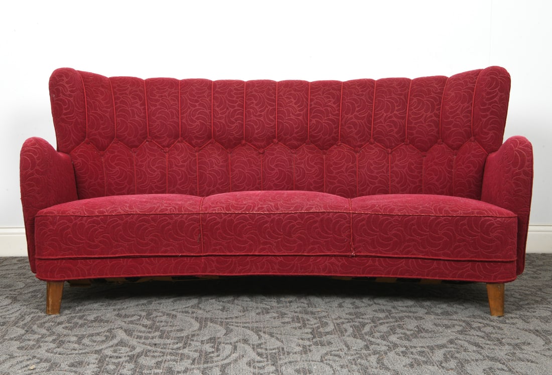 SCANDINAVIAN MID-CENTURY BANANA SOFA C. 1950S: Three-seat sofa with red fabric in damask design. Beech feet. Denmark, circa 1950s. Dimensions: H 36" x W 70" x D 30" x SH 13.5". Condition: Balding to fabric on top of arms and few spots on seat cush