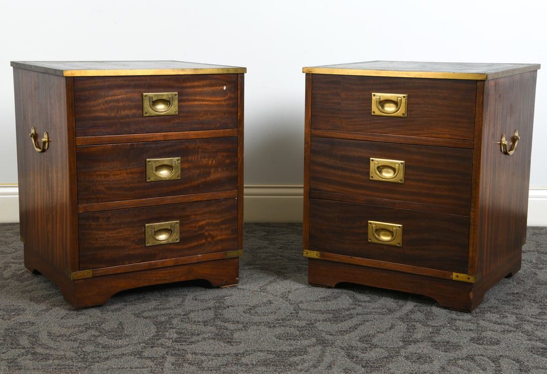 PAIR OF CAMPAIGN STYLE MAHOGANY NIGHTSTANDS: (2) Mahogany nightstands with tooled leather inlaid to tops. Brass pulls and brass trim to tops. circa 1970s. Dimensions: H 22.75" x W 18.5" x D 18.5". Condition: Scratches and rubs to leather. White