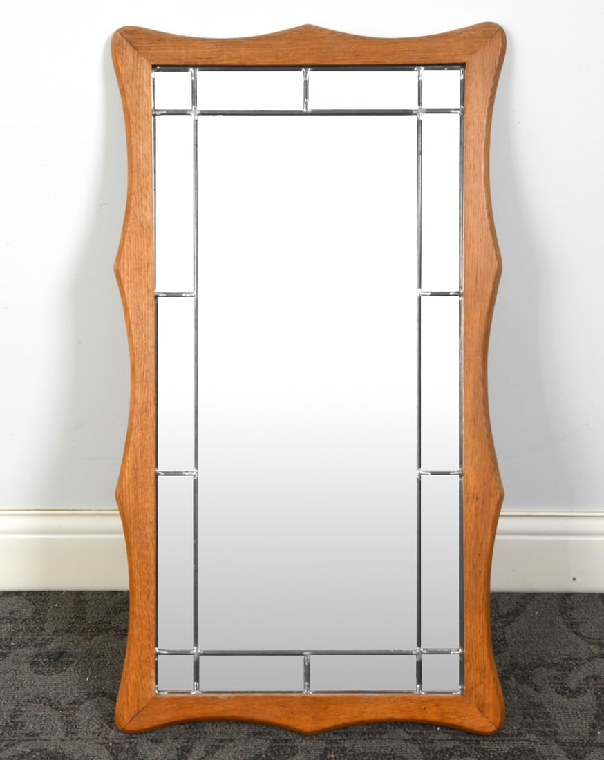 DANISH OAK WALL MIRROR C. 1970S: Oak frame with curved edge. Leaded glass. Denmark, circa 1970s. Dimensions: H 35" x W 19.5". Condition: Wear consistent with age and use.