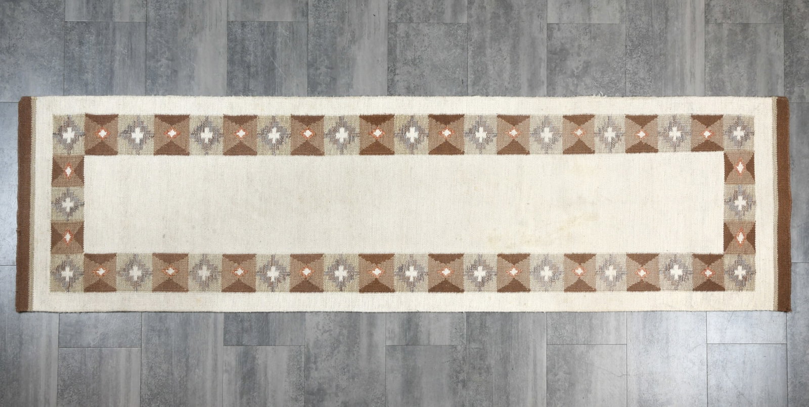 DANISH FLATWEAVE WOOL RUNNER RUG C. 1970S: Wool rug with beige and brown tones in flat weave. Denmark, circa 1970s. Dimensions: L 115.5" x W 32". Condition: Few faintly discolored areas. Wear consistent with age and use.