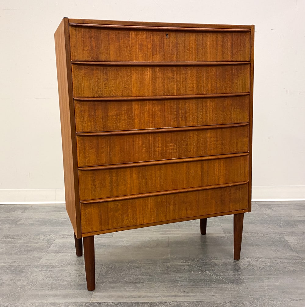DANISH TEAK CHEST OF DRAWERS C. 1960S: Teak chest of drawers with elongated drawer pulls. Denmark, circa 1960s. Dimensions: H 41.25" x W 30.5" x D 16". Condition: No key. Missing keyhole cover. Scuffs and scratches to top. Wear consistent 