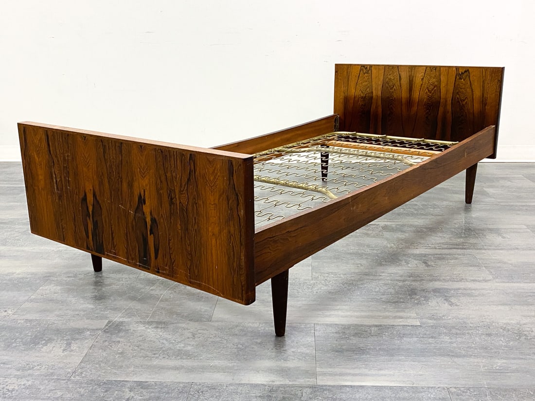 HANS WEGNER STYLE DANISH ROSEWOOD TWIN BED FRAME: Rosewood bedframe with metal springs. Denmark, circa 1960s. Dimensions: H 25" x W 78" x W 36". Interior W 33.75" x D 75". Condition: Sun fading. Scratches, scuffs, and dings. Wear consistent with age 