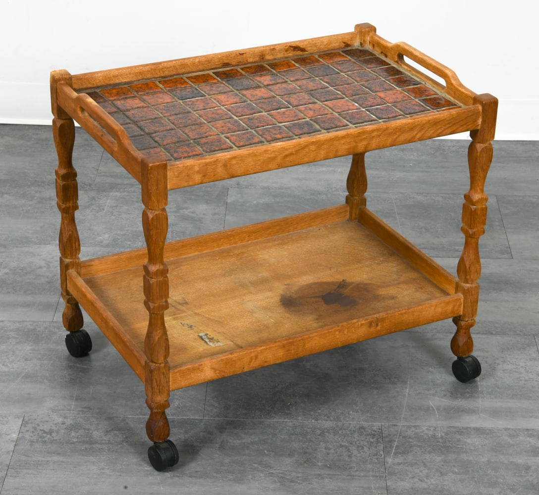 DANISH OAK & CERAMIC TILE BAR CART C. 1960S: Oak bar cart with red ceramic tiles inlaid to top. On castors. Denmark, circa 1960s. Dimensions: H 22" x W 24.5" x D 16.5". Condition: Water spots and discoloration to lower shelf. Wear consistent wit