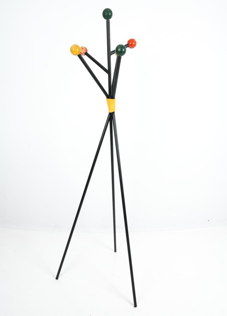 ATTR. ROGER FERAUD ATOMIC COAT RACK C. 1950S: Mid-century coat rack in black lacquered steel frame. Topped with six arms with wooden spheres in green, yellow, and orange-red tones. Central junction with a yellow plastic cord details and tripod ba