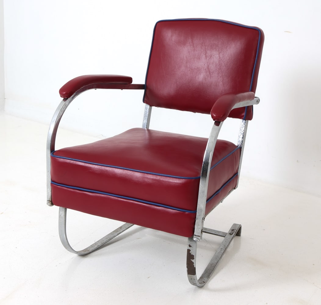 KEM WEBER FOR LLOYD CHROME LOUNGE CHAIR 1930S: Art deco cantilever lounge chair designed by Kem Weber and manufactured by Lloyd in 1937. Curved chromed steel base and red vinyl upholstery with blue edge details. Partial tag presents to frame. Circ