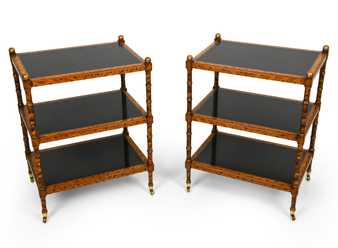PAIR OF REGENCY STYLE 3-TIERED SIDE TABLE: Three tiered side tables on metal casters. Black lacquered shelves and tiger bamboo inspired painted wooden frame with gold tone finials. Dimensions: H 28" x W 21.25" x D 15.25". Condition: Scuffs and