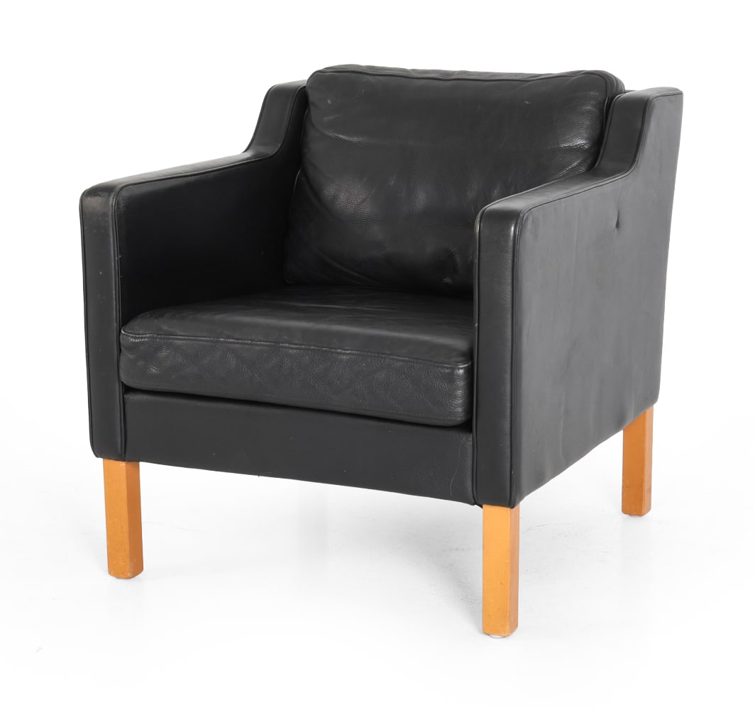 STYLE OF MOGENSEN DANISH LEATHER LOUNGE CHAIR: Lounge chair in black leather upholstery and beech legs. Sloping arms and loose cushions. Denmark, circa 1970s. Dimensions: H 29" x W 27.5" x D 31" x SH 16" Condition: Wear consistent with age and use