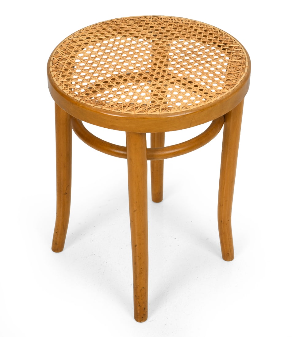 ROMANIAN BEECH & CANE STOOL C. 1960S: Round beech bentwood stool with curved legs and cane seat. Romanian quality stamp underneath the seat. Circa 1960s. Dimensions: H 18.5" x Dia 14.5" Condition: Minor scuffs and scratches. Minor fraying