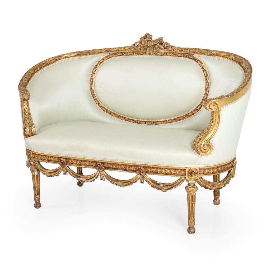 ANTIQUE LOUIS XVI STYLE GILTWOOD SETTEE: Carved frame with classical motifs and turned fluted legs with curved apron in gold finish. Oval-padded backrest and cream tone upholstery. Dimensions: H 29" x W 48.5" x D 22.25" x SH 15.25". Conditio