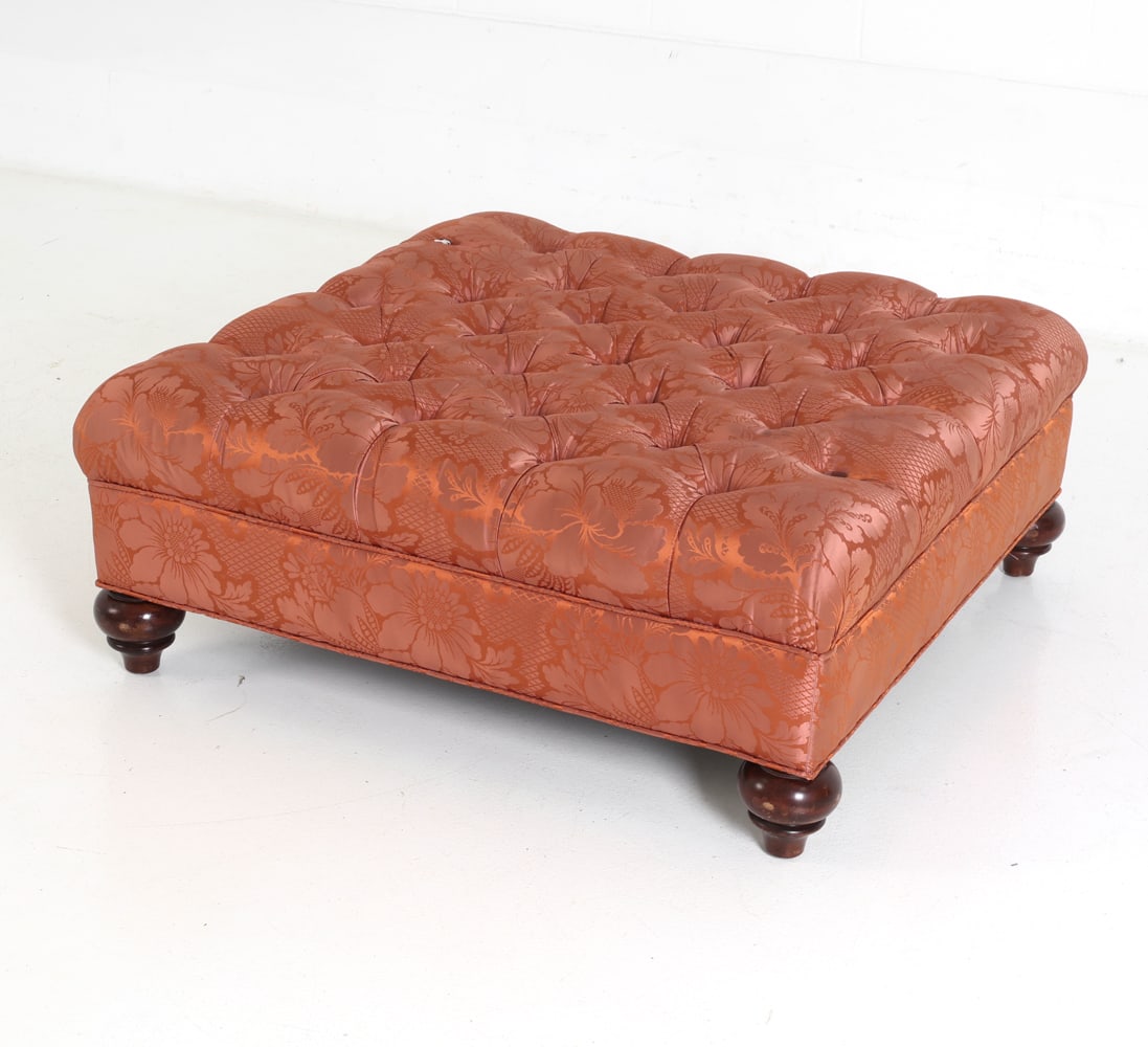 BAKER STYLE TUFTED COCKTAIL OTTOMAN: Square top bench ottoman with buttoned tufted top and floral damask patterned upholstery. Short turned wooden legs. Dimensions: H 14" x W 42" x D 42" Condition: Wear consistent with age and use. Scuff