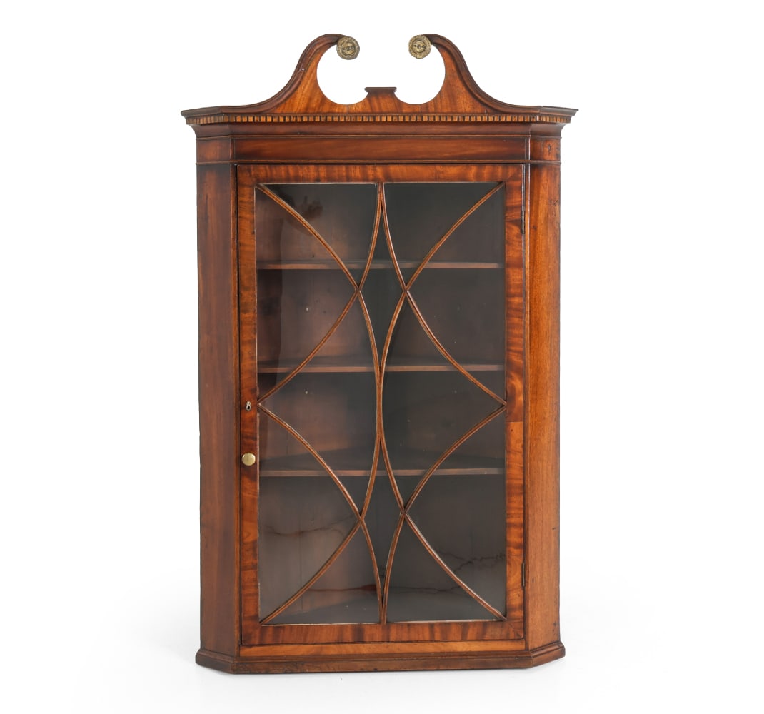 ANTIQUE GEORGIAN MAHOGANY CORNER CABINET: Key included. Mahogany with curved details. Curved pediment over glass doors. Three shelves. Label of UK mover presents to back. 19th century. Dimensions: H 48" x W 30" x D 18". Condition: Previous re
