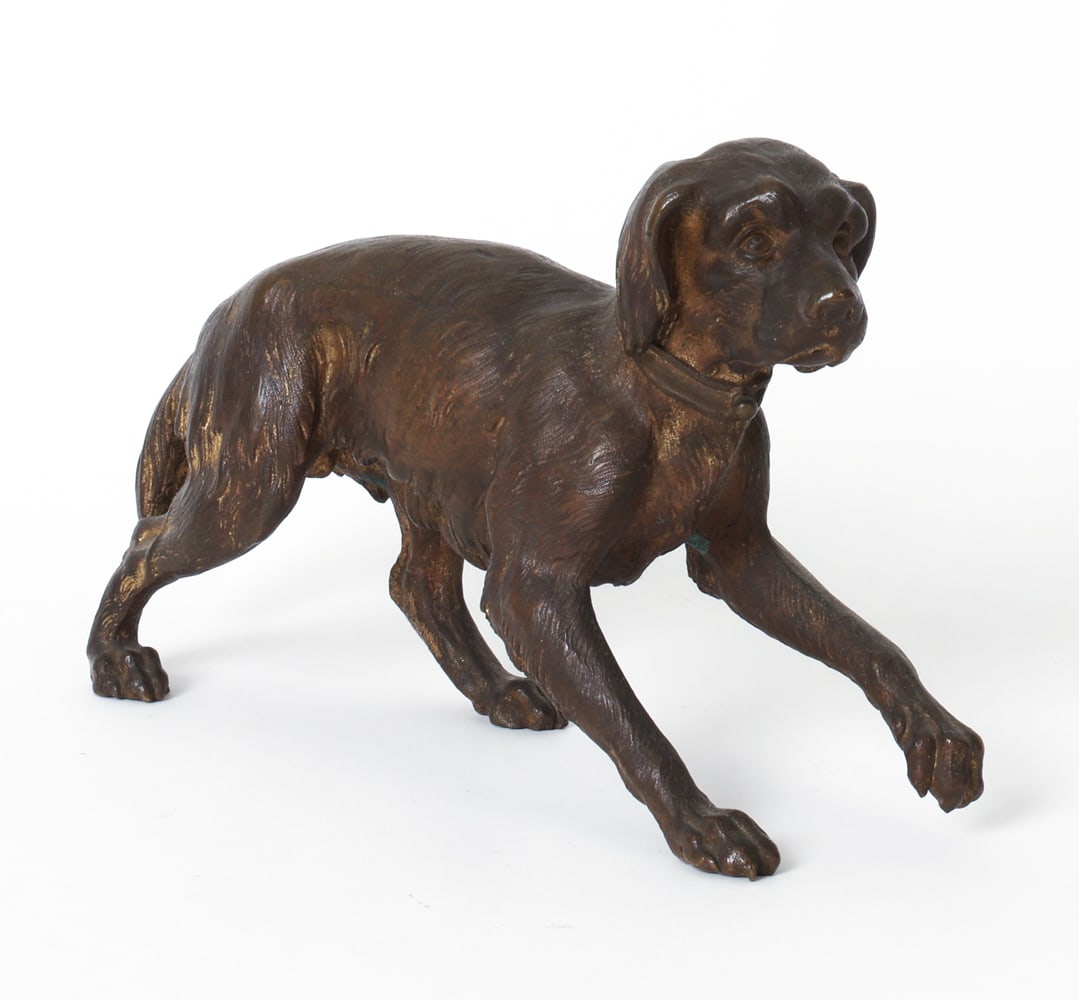 ANTIQUE BRONZE DOG FIGURINE: Marked 'L' underneath paw. Likely previously mounted to a base. Late 19th century. Dimensions: H 5" x W 3.5" x D 10". Condition: Oxidation underneath. Light discoloration. Wear consistent with age and