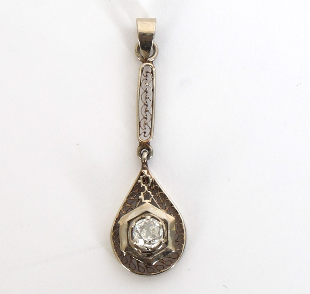 14K WHITE GOLD AND DIAMOND PENDANT: With filigree design and 14k white gold with a diamond. Marked to clasp. Dimensions: L 1.5". Condition: Faint scuffs, wear consistent with age and use.