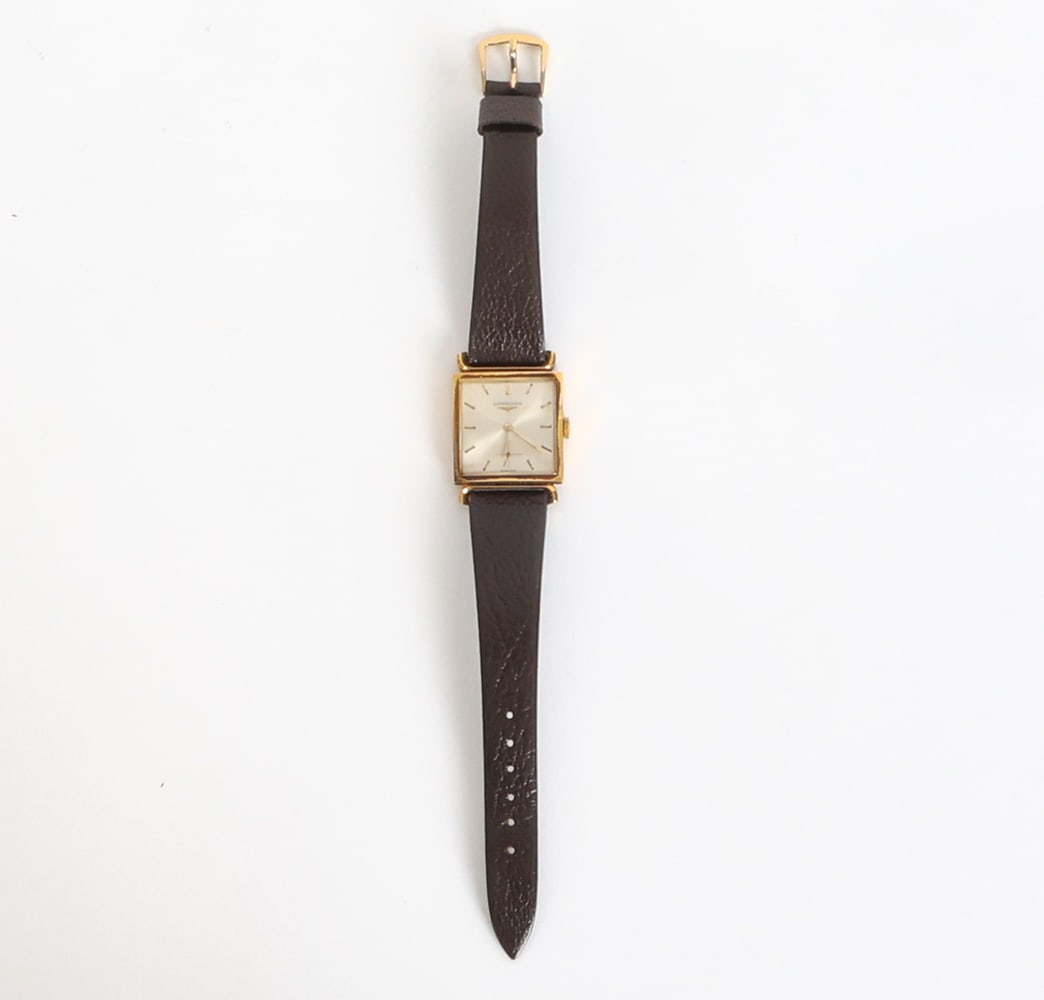 LONGINES 18K GOLD WATCH: 18K Gold cased watch with leather strap. Tested. Dimensions: L 9". Condition: Timekeeping untested. Scuffs and rubs to case, darker discoloration to one side. Wear consistent with age and use.