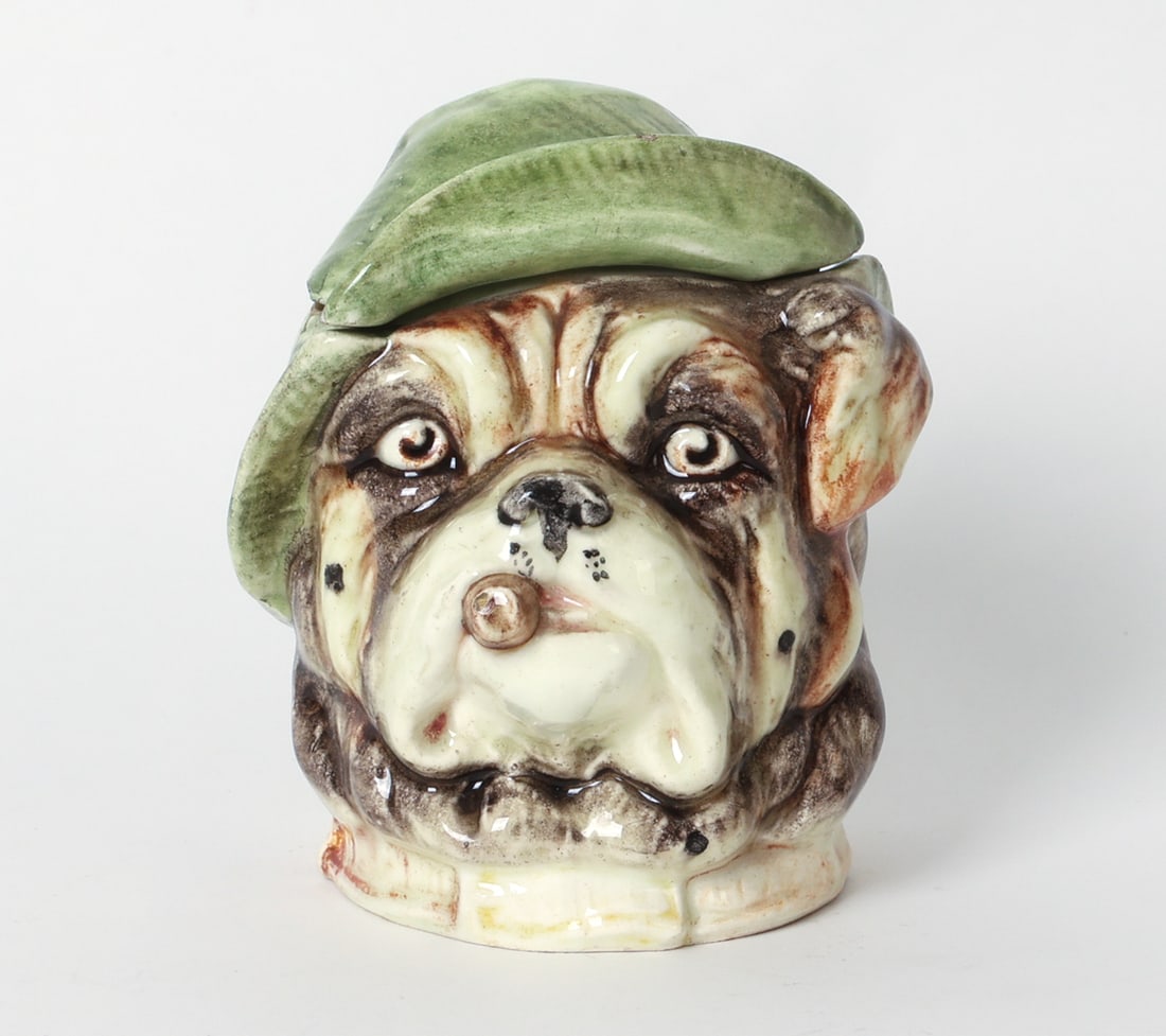 ANTIQUE MAJOLICA BULLDOG HUMIDOR: Marked underneath. Ceramic bulldog head humidor or tobacco jar. Late 19th century. Dimensions: H 5" x Dia. 4". Condition: Previous repair near top. Small chips to edge of list. Other scuffs and rubs. 