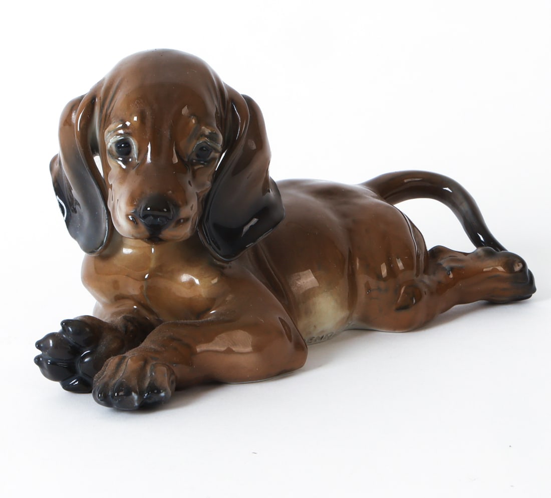 FRITZ HEIDENREICH ROSENTHAL PORCELAIN DOG FIGURE: Marked underneath and to side. Porcelain ceramic figure of a dachshund puppy. Circa 1940s. Dimensions: H 5" x W 4.5" x D 8.5". Condition: Wear consistent with age and use as displayed.