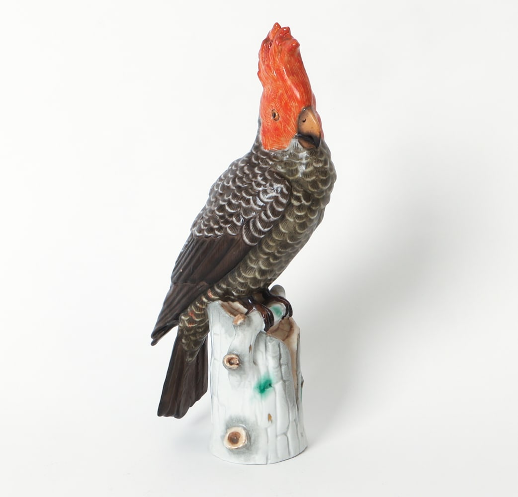 ERNST BOHNE & SOHNE PORCELAIN COCKATOO: Marked underneath. Porcelain figure of a cockatoo perched on a stump. Circa early 1900s. Dimensions: H 11.25" x W 3.5" x D 4.5". Condition: Light surface marks. Wear consistent with age and use.