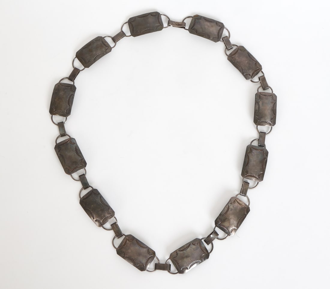 STERLING SILVER CONCHO BELT: Sterling silver concho hat band with etched decoration to rectangular pieces. Marked to clasp. Total Weight: 3.57 ozt. Dimensions: L 31". Condition: Light scuffs and some tarnish. Wear consistent with