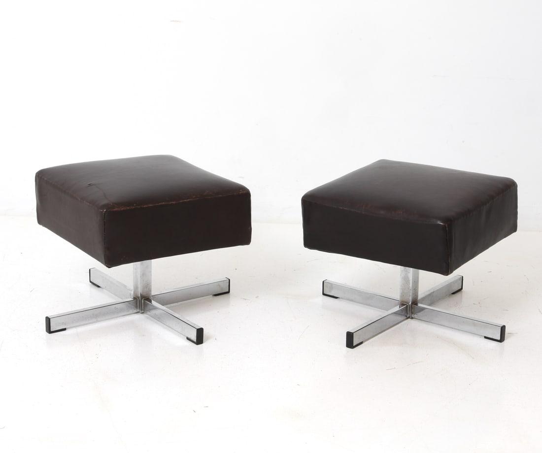 PAIR OF SCANDINAVIAN LEATHER FOOTSTOOLS 1970S: (2) Stools with dark brown leather seats and steel cross-shaped bases. Scandinavian, circa 1970s. Dimensions: H 16" x W 18" x D 18". Condition: Scuffs and rubs to leather, mostly on corners. Scratches