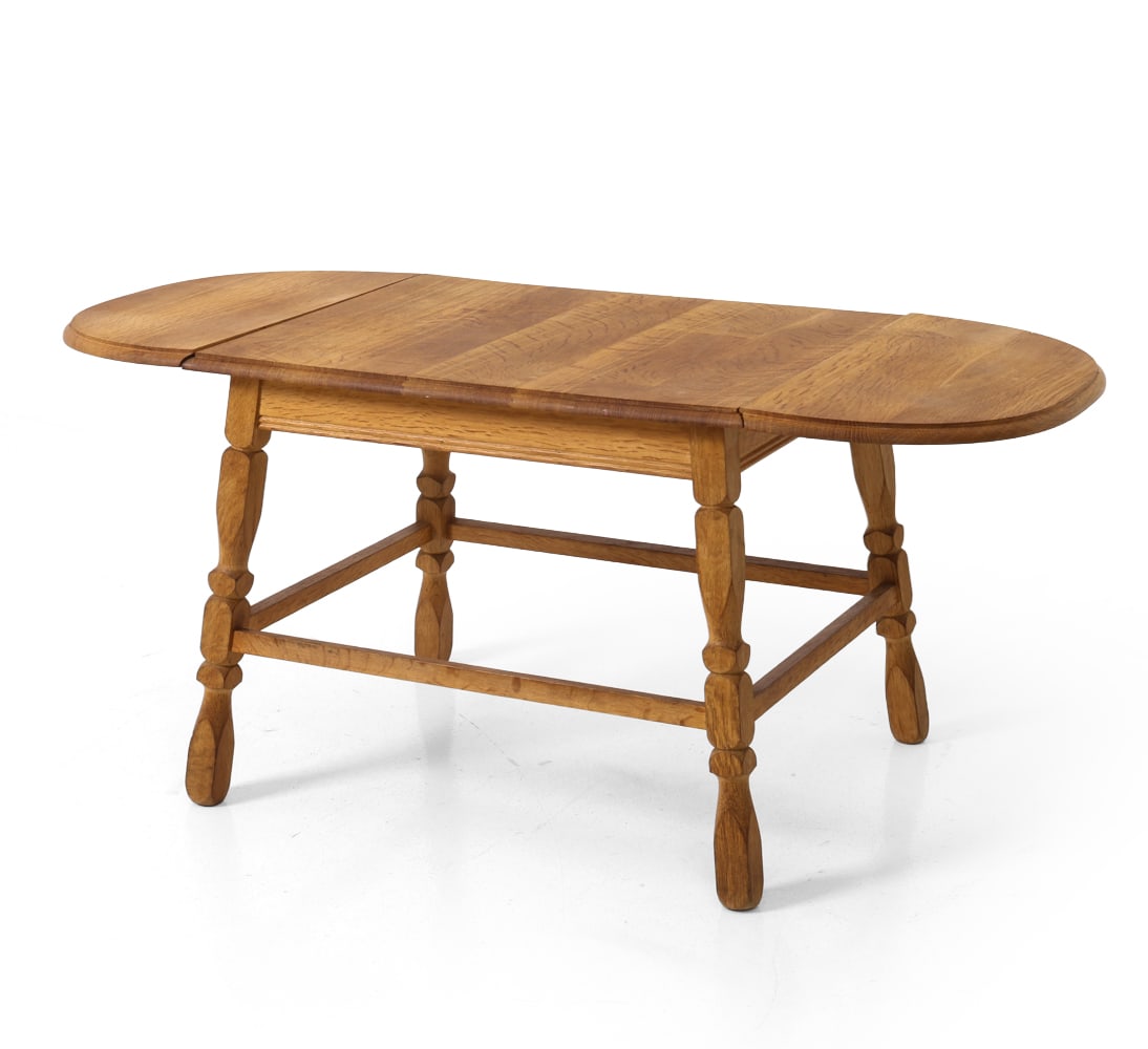 DANISH OAK DROP-LEAF COFFEE TABLE C. 1970S: Oak coffee table with (2) drop leaves. Turned legs and stretcher base. Denmark, circa 1970s. Dimensions: H 22" x W 26.75" x D 21.5". Leaves W 11". Condition: Few faint water rings. Wear consistent wit