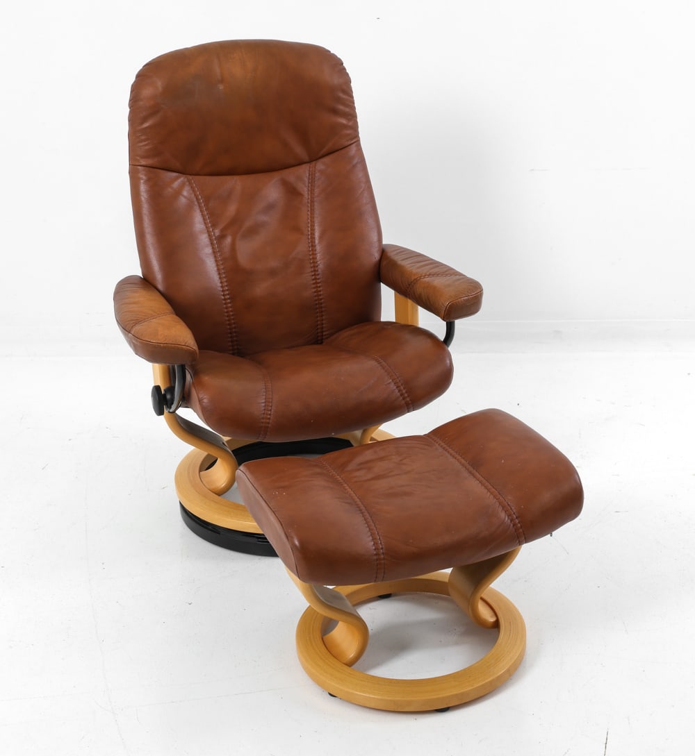 EKORNES STRESSLESS M. CONSUL CHAIR W/ OTTOMAN: Round beech base with brown leather upholstery. Includes ottoman. Norway, circa 1970's. Dimensions: H 41" x W 29.75" x D 24" x Sh 16.5" (Ottoman) H 15" x W 21" x D 14.5" Condition: Sun-fading to armre