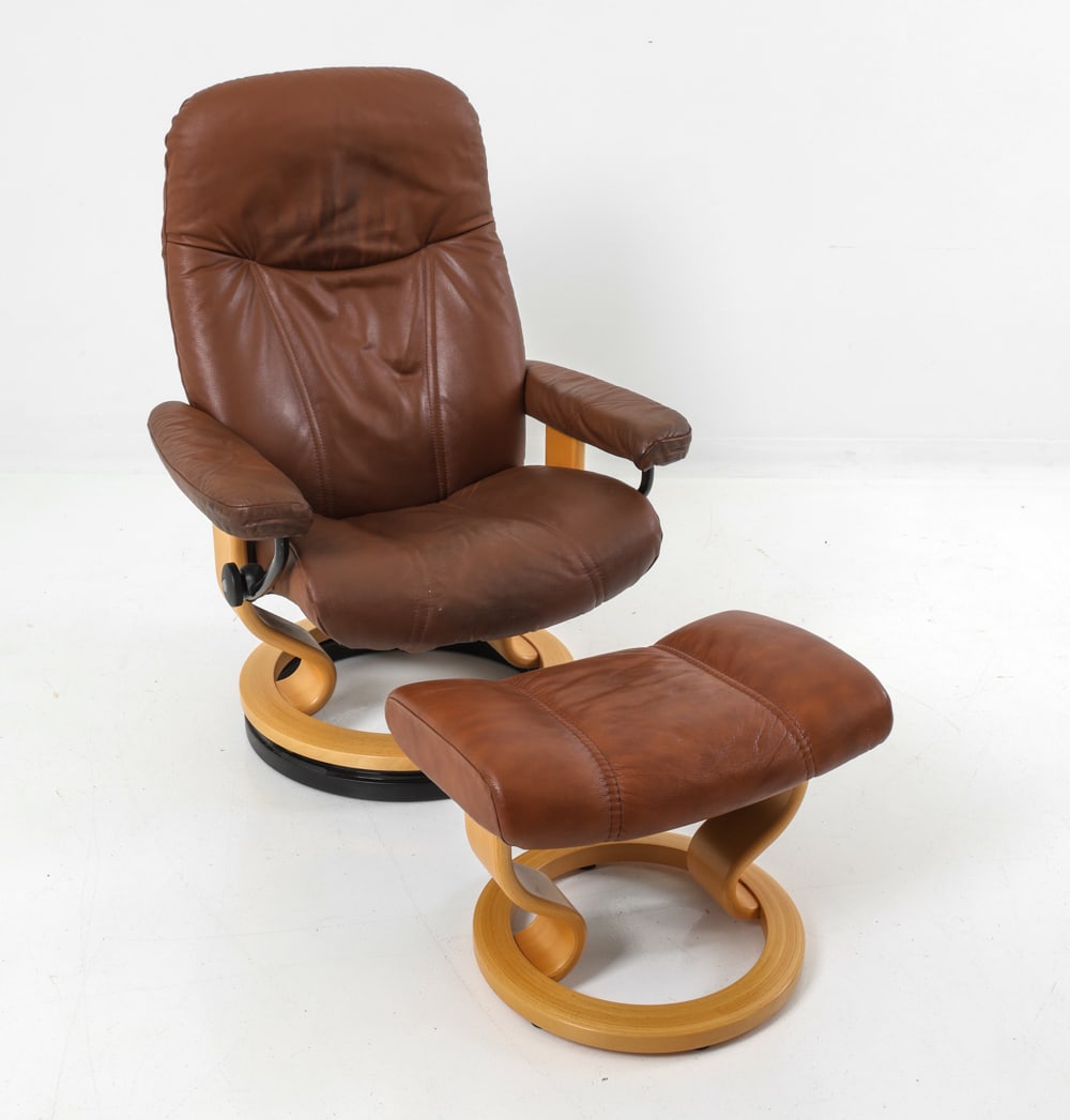 EKORNES STRESSLESS M. CONSUL CHAIR W/ OTTOMAN: Round beech base with brown leather upholstery. Includes ottoman. Norway, circa 1970's. Dimensions: (Chair) H 42" x W 29" x D 24" x SH" 17" (Ottoman) H 15" x W 21" x D 15" Condition: Gentle creasing w