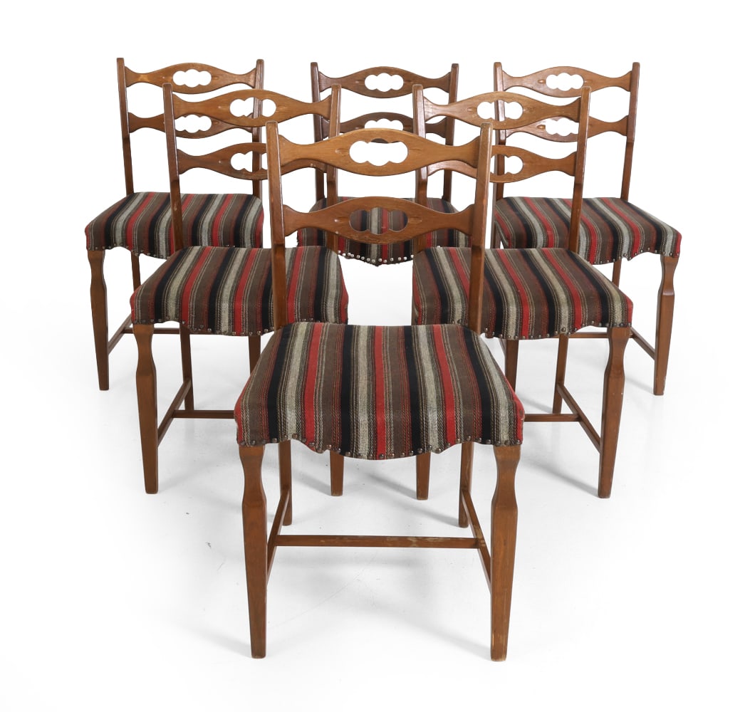 (6) HENNING KJAERNULF DANISH OAK DINING CHAIRS: Six dining chairs in stained oak. Stripe upholstered seat and curved backrests with carved details. Apparently unmarked. Denmark, circa 1960s. Dimensions: H 33" x W 18" x D 18" S.H. 17.5" Condition: S